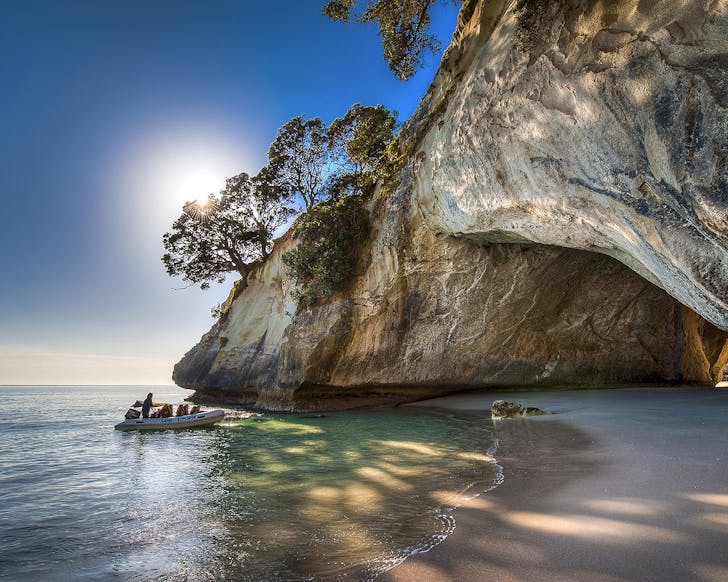 A boat pulls up to Cathedral Cove in the Coromandel, one of New Zealand's most stunning beaches.