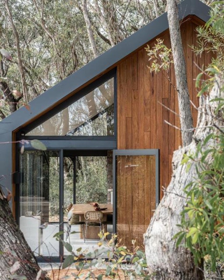 A view of a chalet surrounded by trees at Chalets at Blackheath one of the best romantic getaways in Australia