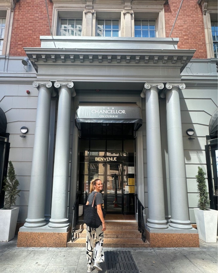 A woman walks through the entrance to Chancellor on Currie one of the best Adelaide hotels