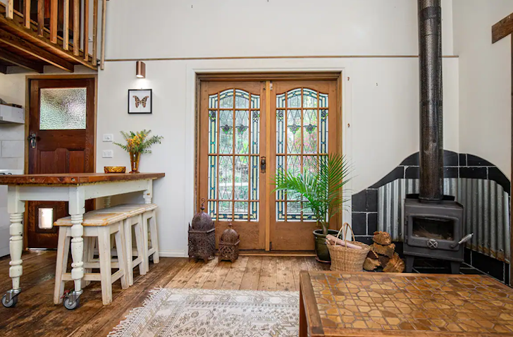 The indoor fireplace and dining table at the Chapel Sanctuary Airbnb Victoria