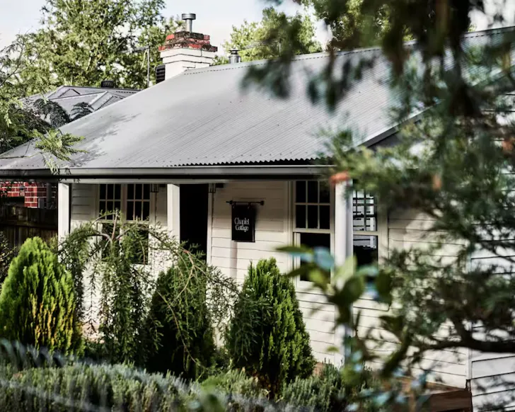 The quaint white exterior of Chaplet Cottage one of the best romantic getaways in Australia