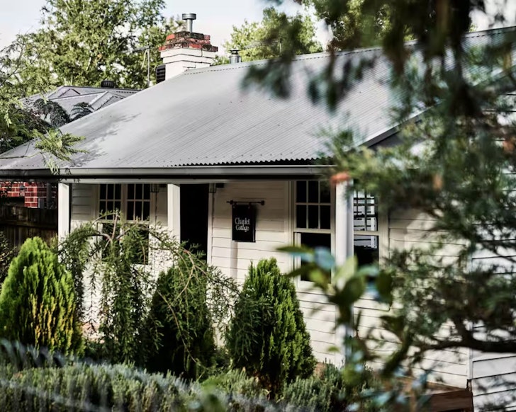 The quaint white exterior of Chaplet Cottage one of the best romantic getaways in Australia