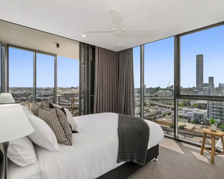 A view of the bedroom overlooking the city at Chic Two-Bedder pet-friendly Airbnb Brisbane