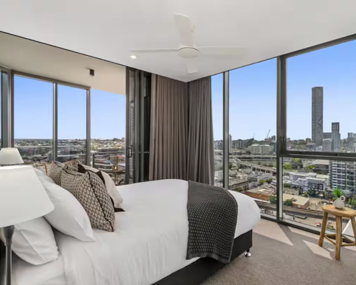 A view of the bedroom overlooking the city at Chic Two-Bedder pet-friendly Airbnb Brisbane