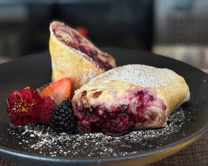 A close up of Chula's Berry Cheesecake Chimichanga, which looks like a dessert burrito with berries and cream. 