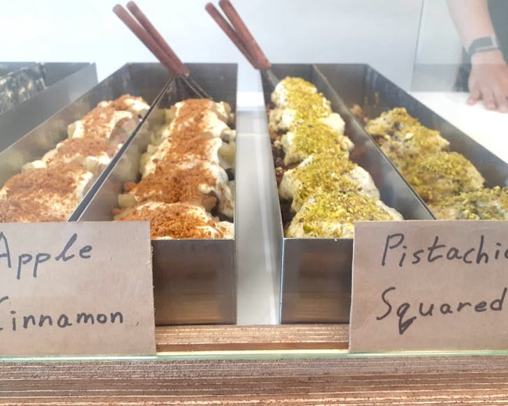 Rows of squarish cinnamon buns in apple and pistachio. 