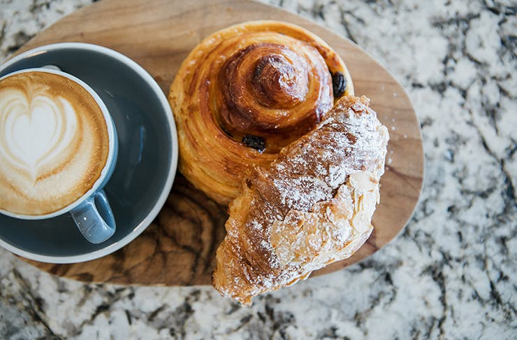 A fresh croissant and Danish with a coffee.