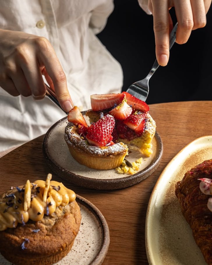 Slicing a delicious dessert cake topped with strawberries