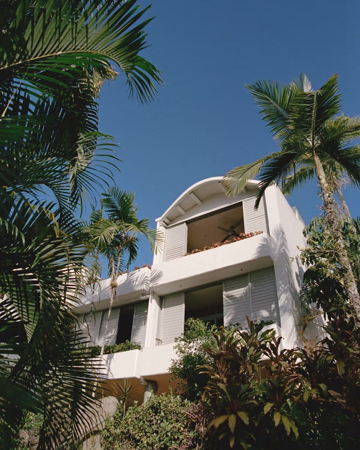 An exterior view of Club Tropical surrounded by palm trees, one of the best Port Douglas Airbnbs
