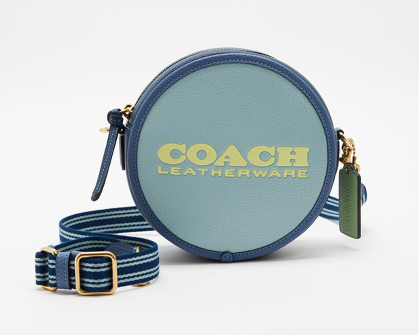 A blue circular handbag with a striped strap and 'Coach leatherware' written in yellow