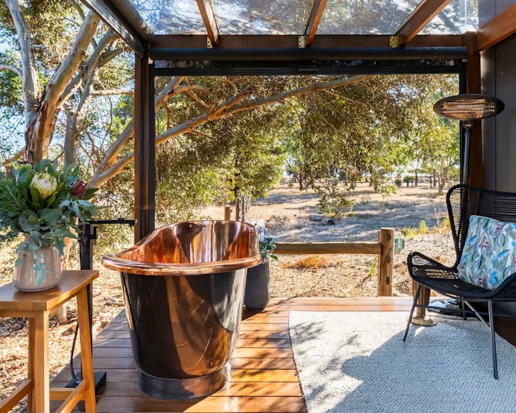 The copper bath on the deck of Coach Light Cabin one of the best tiny houses in Australia
