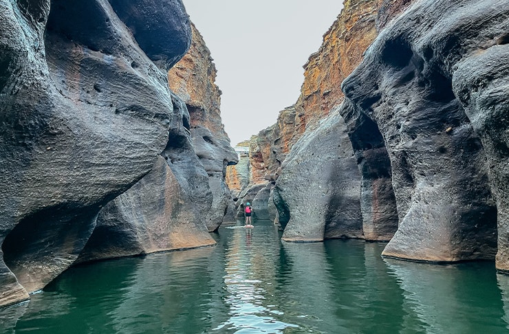 a person on a SUP in a deep gorge