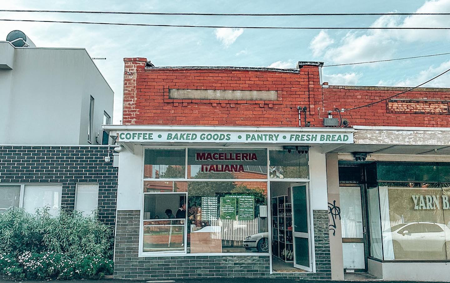 A shopfront of a milk bar in a quiet street.