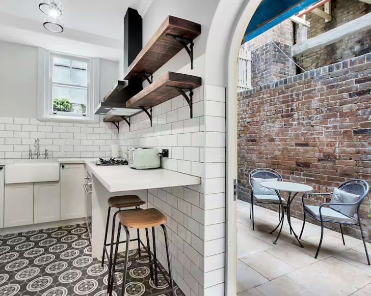 A view of the black and white kitchen and patio at Cockatoo Apartment Sydney CBD