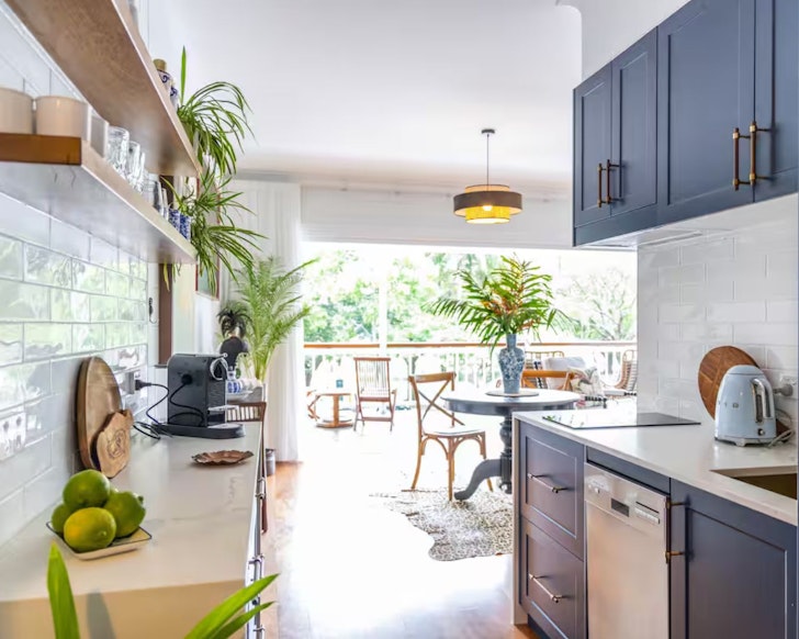 A view from the kitchen out to the lounge and balcony at Coco's one of the best Port Douglas Airbnbs