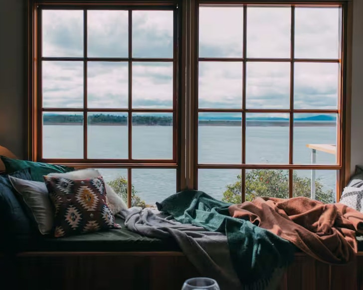 A view of the water out the window of Coldwater Cabin one of the best lake house Airbnbs Tasmania