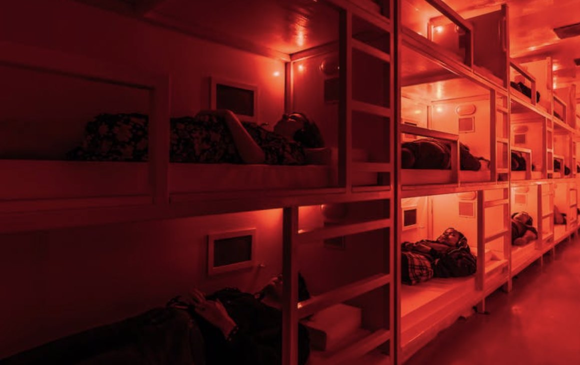 Audience laying inside bunk beds in a shipping container for COMA