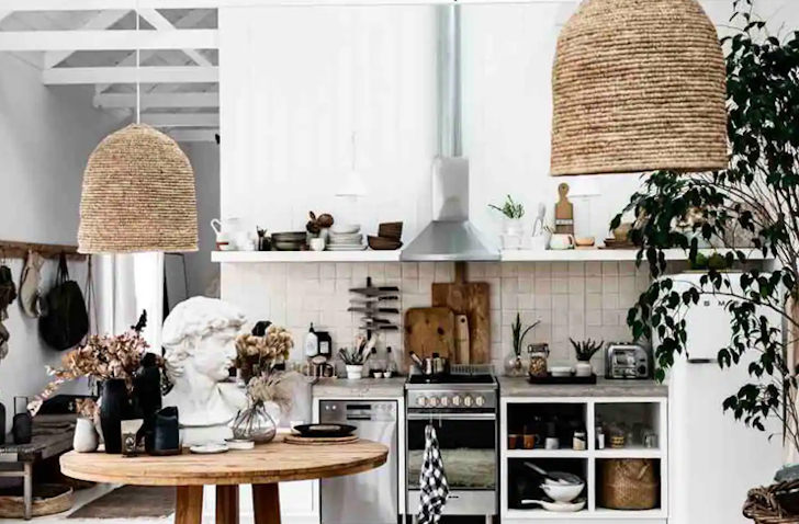 A dining-kitchen room with white walls, and a kitchen against the back wall.