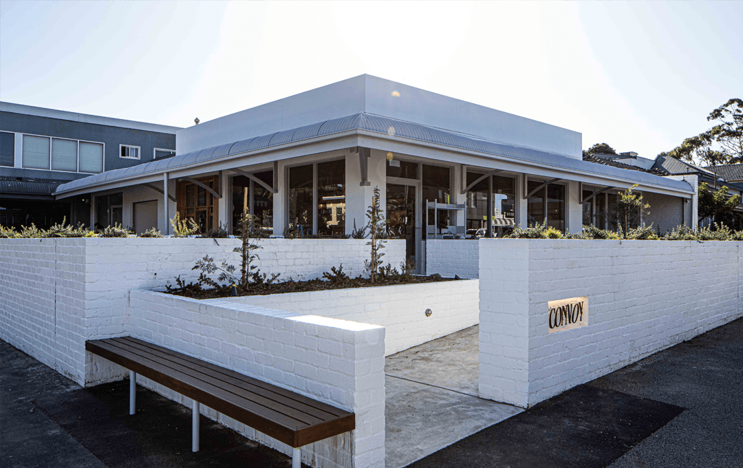 A corner cafe with white-brick fence.