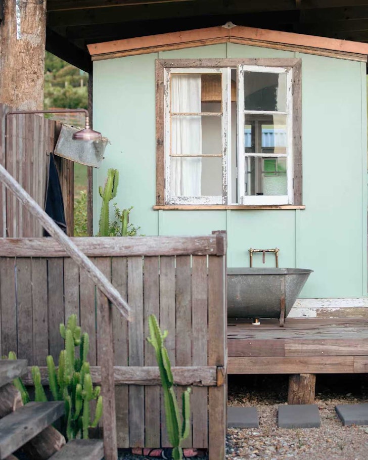The pale green exterior of Coopers Cabin tiny home in South East Queensland