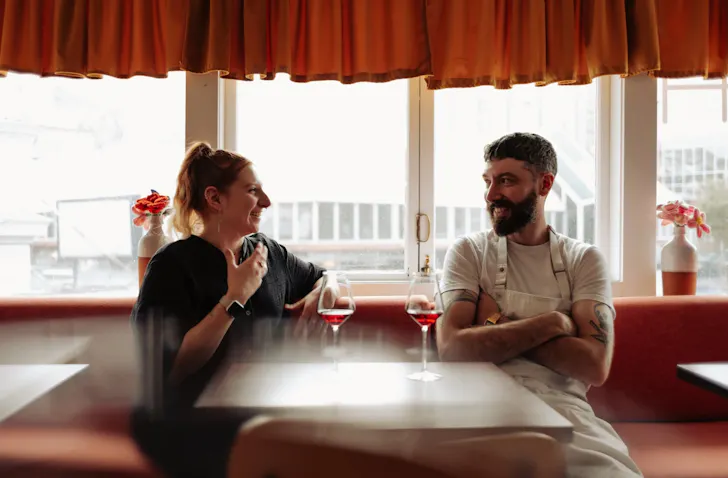 The owners of Supra restaurant in Wellington sitting in front of a window