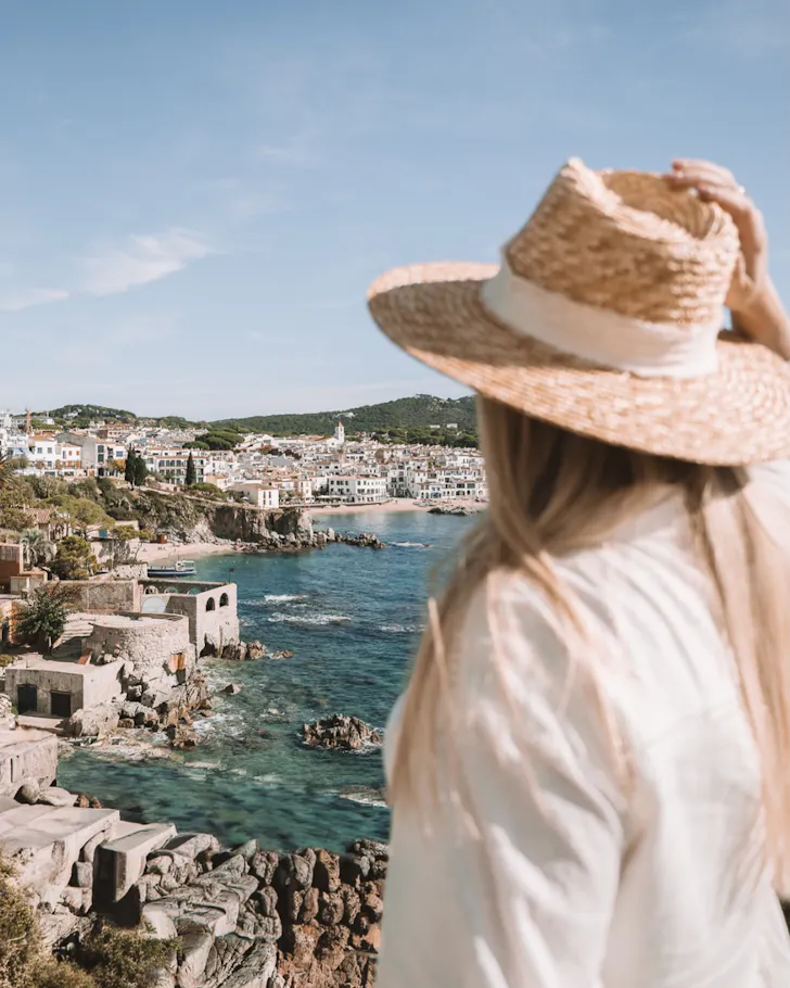A female traveller overlooking the beautiful whitewashed houses on the edge of the Mediterranean Sea in Tossa de Mar, Barcelona.