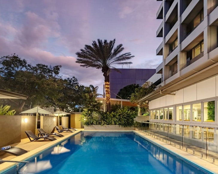 A view of the pool with a palm tree at the end at Courtyard by Marriott Darwin one of the best Darwin hotels