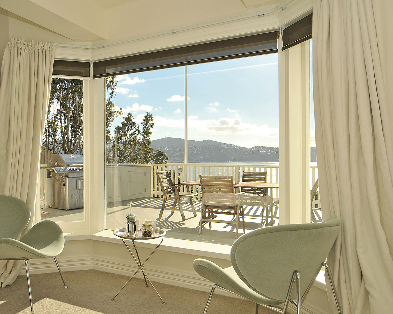 One of the best Airbnbs in Wellington, the expansive balcony at Crescent Studio boasts an outdoor dining set up and sweeping ocean views.