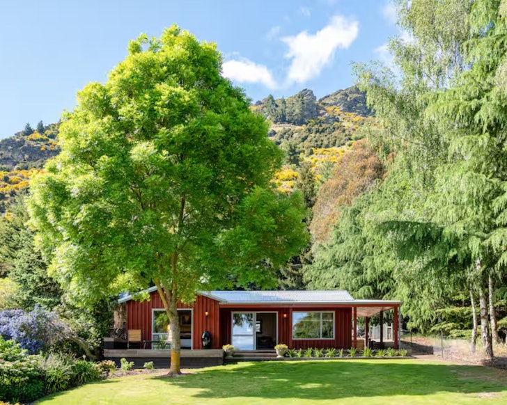 A view of Criffel Bluffs Cottage surrounded by trees, one of the best accommodation options in Wanaka New Zealand
