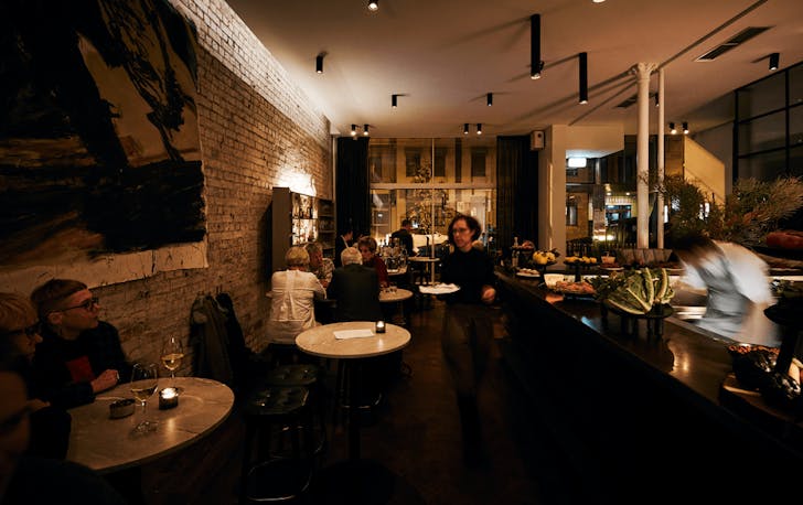 A dimly lit diner, with people sitting at tables, one of Fitzroy's best restaurants. 