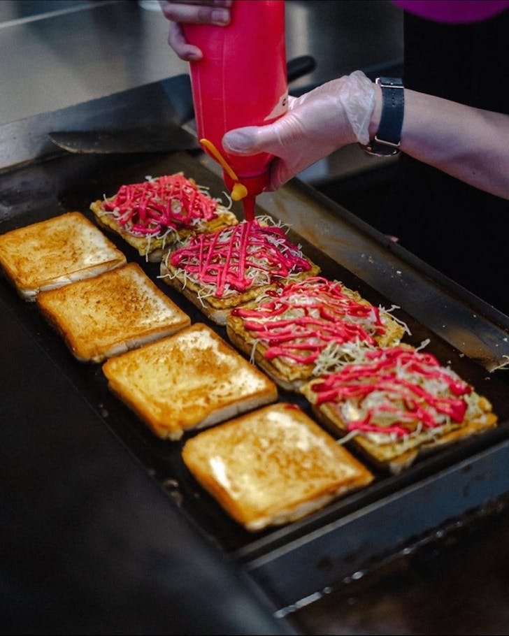 Cyber Toast sandwich with ham, Korean vegetable omelette, cheese, cabbage and bright pink sauce.