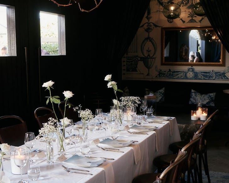 The Decanter Room at Tantalus, with a long table dressed in white with white roses and wine glasses, ready for a wine tasting. 