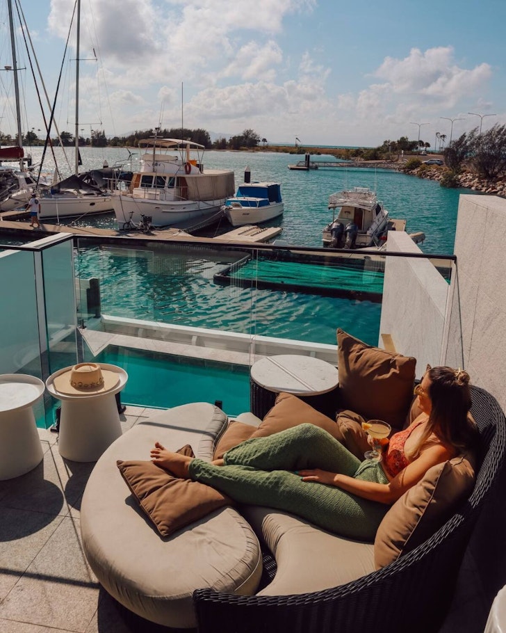 A woman lounges by the pool at Dacha on Maggie Airbnb one of the best stays near Townsville
