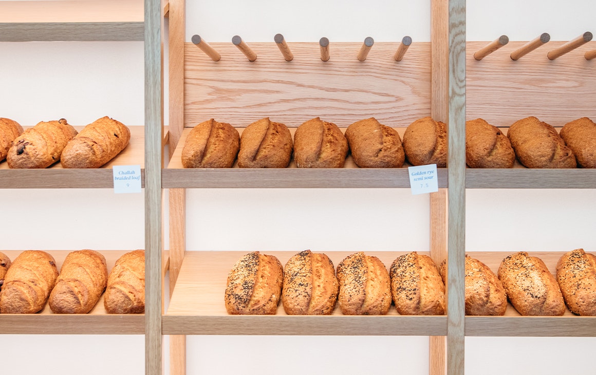 a wall of shelves filled with loaves of sourdough bread