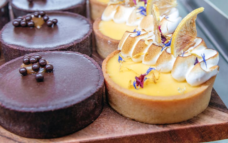 a chocolate and passionfruit tart lined up in a cabinet