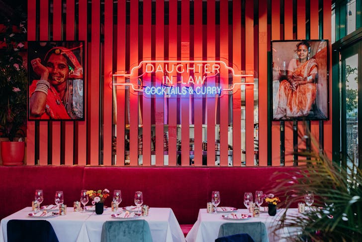 a table setting with a neon sign in the background