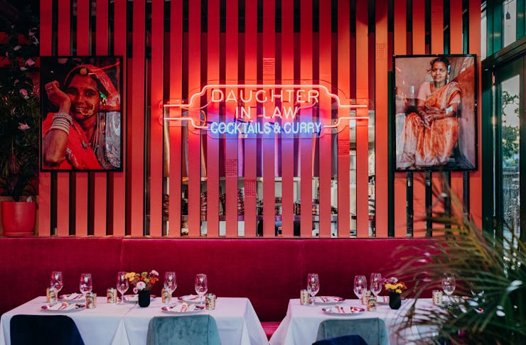 a table setting with a neon sign in the background