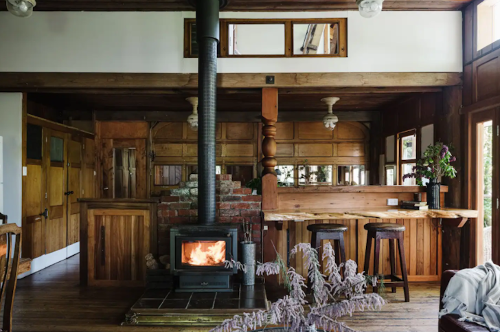 The indoor wood burner and kitchen at Otways Loft one of the best large group Airbnbs Victoria