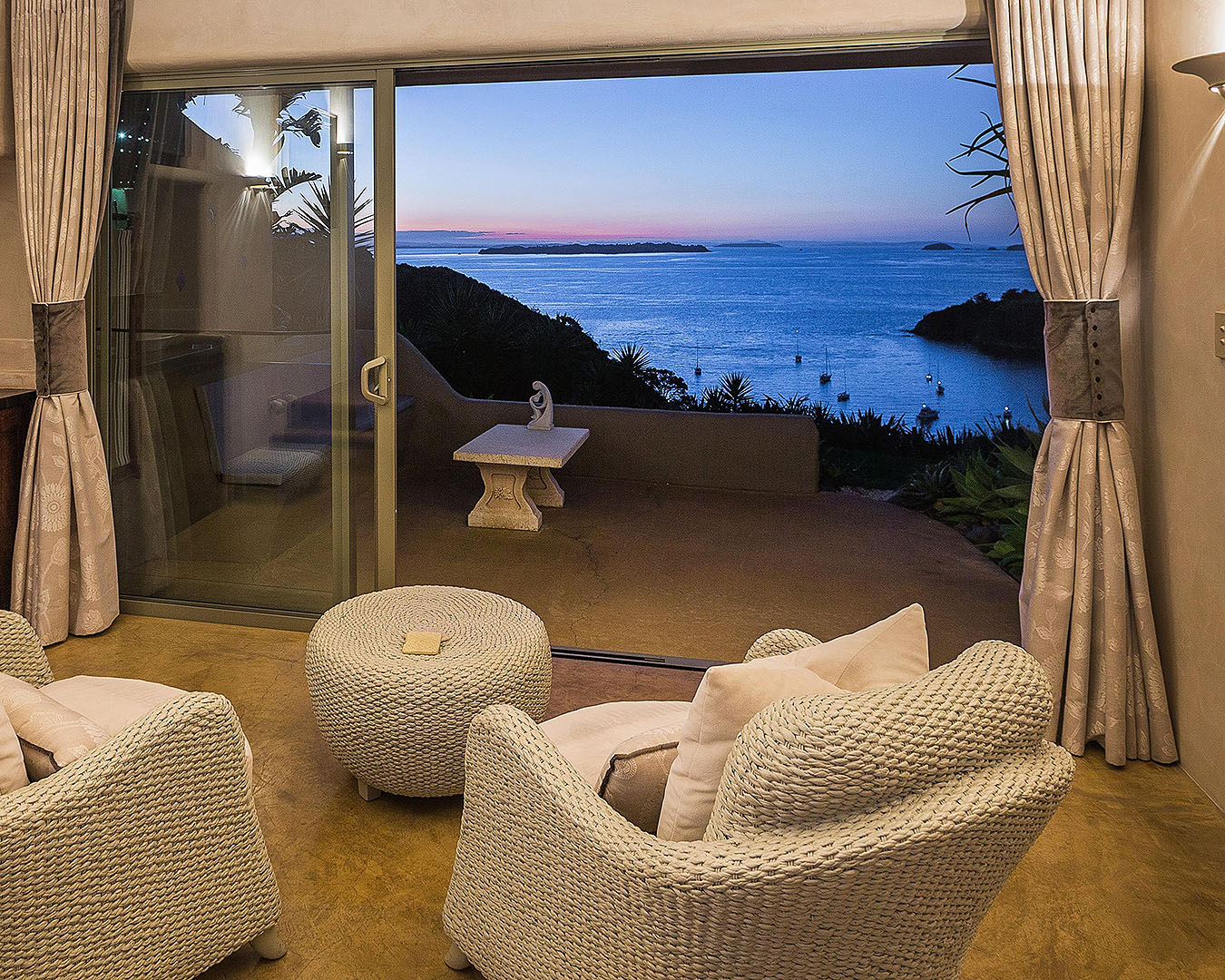 A room looks out on a stunning sunset on Delamore Lodge on Waiheke Island.