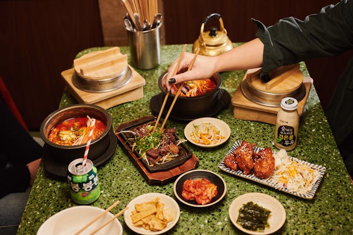 Plate of food with hands using chopsticks