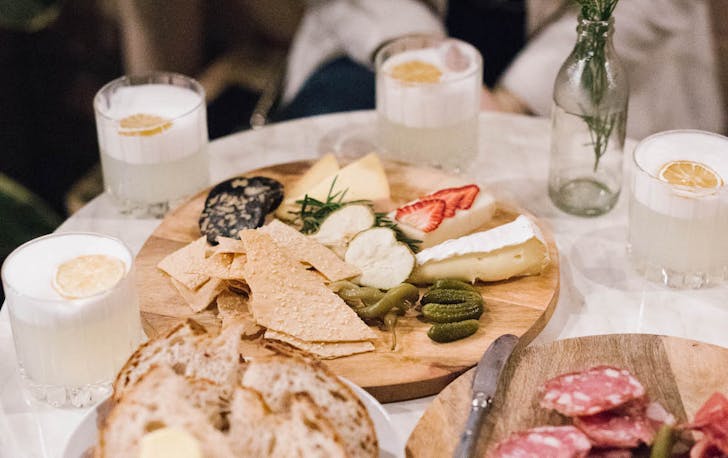 a table filled with gin drinks and cheese boards