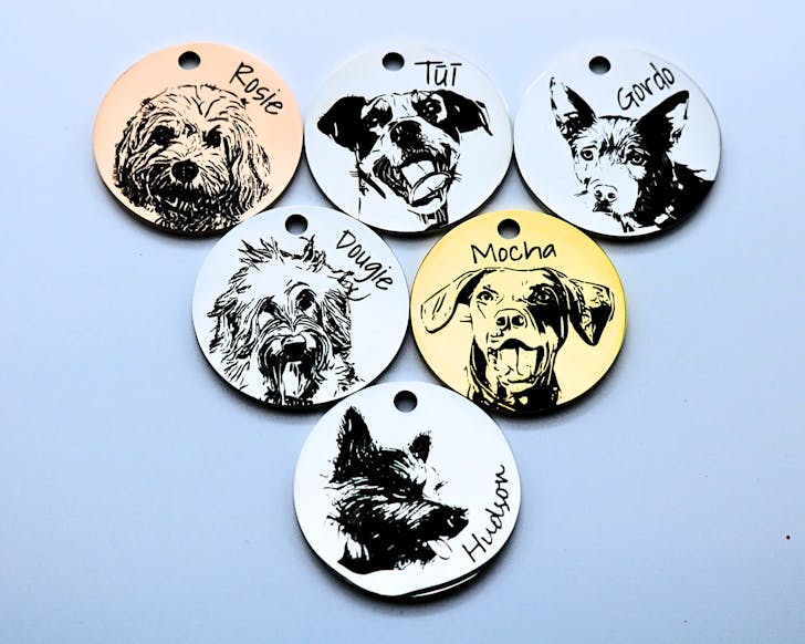 Dog tags featuring laser-cut pet portraits, one of the best dog accessories to adorn your pup with.