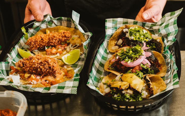 Two trays filled with stacked tacos. 