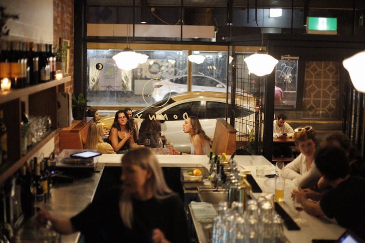 People sitting in busy bar.