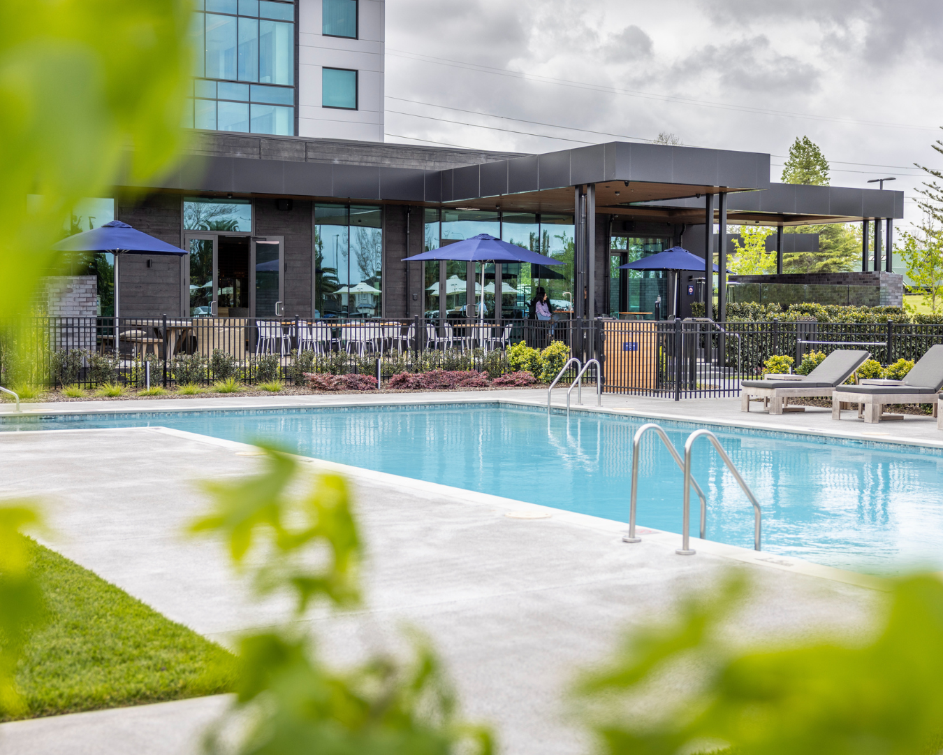 A beautiful blue pool with loungers with Doubletree by Hilton, Karaka in the background