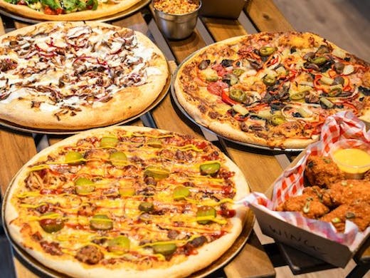 Image of pizzas and wings from Dough Boys