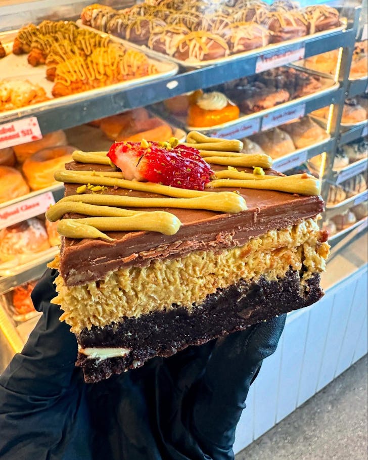 Gloved hand holding Dubai chocolate brownie