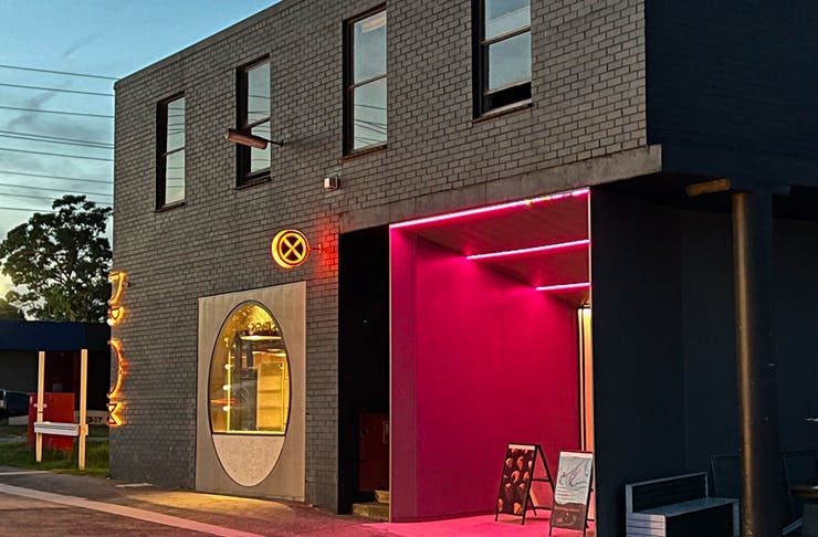The outside of a bakery lit up at night.