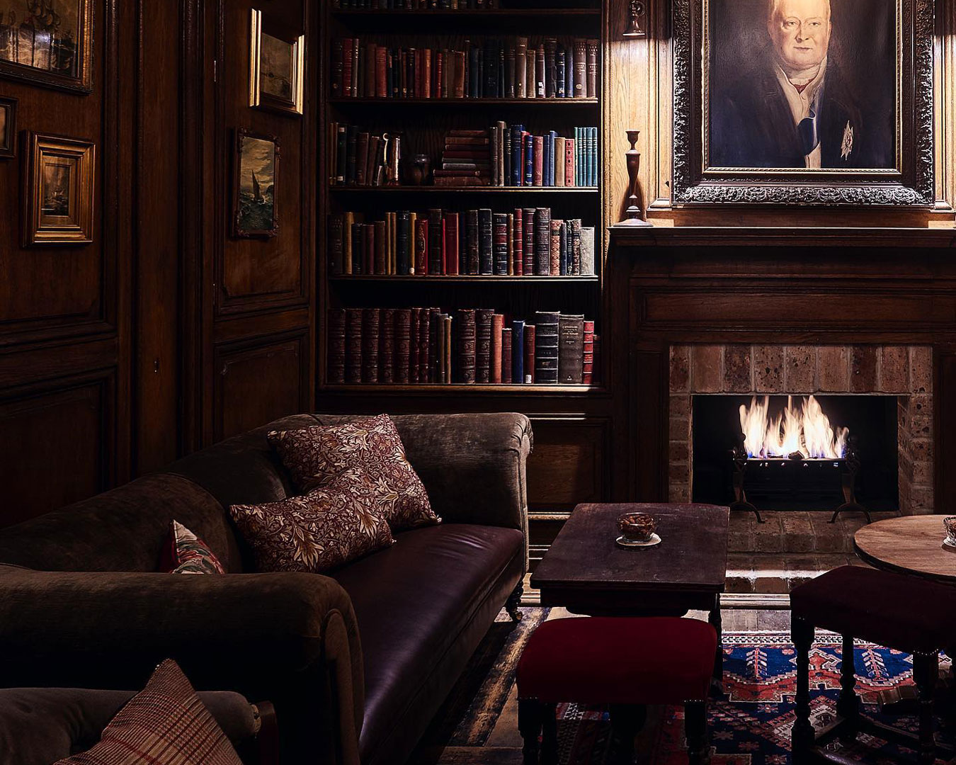 room with leather couch, bookcase and fire