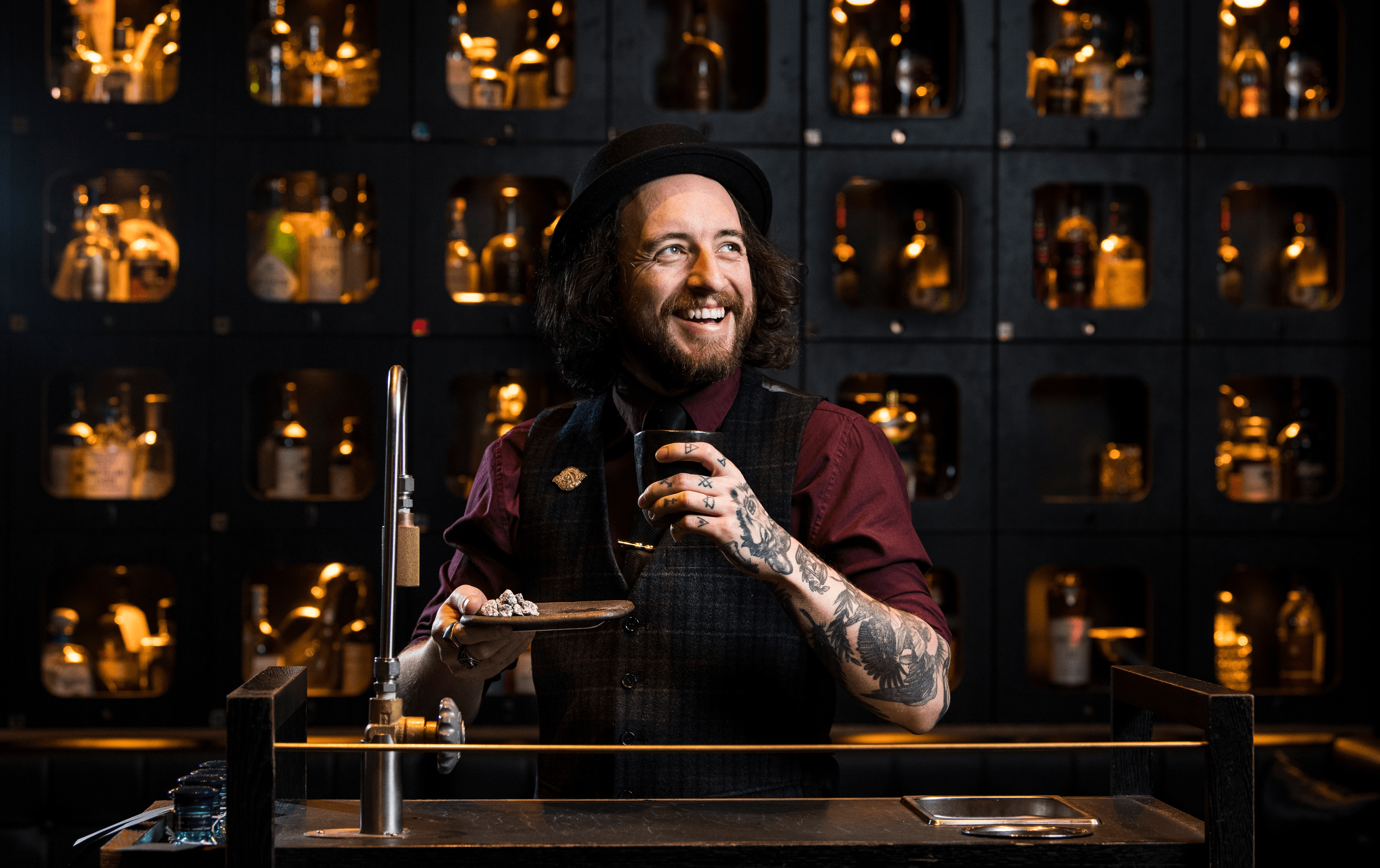 A person smiling while serving cocktails and one of the best cocktails bars Melbourne cbd